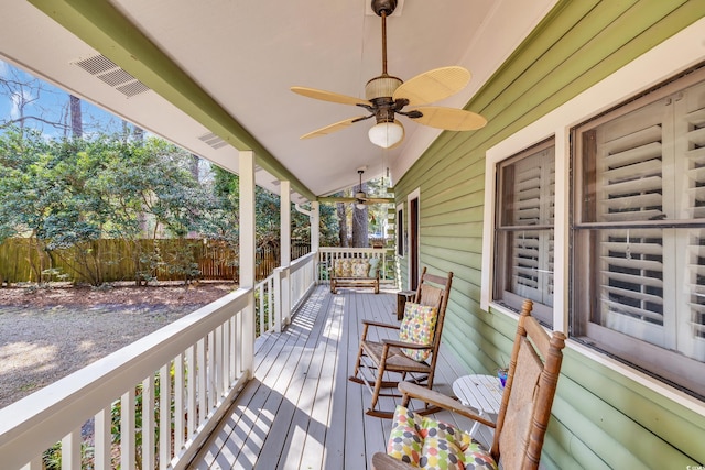 deck with covered porch, visible vents, fence, and a ceiling fan