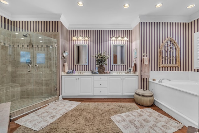 full bath with double vanity, wallpapered walls, a stall shower, a garden tub, and crown molding