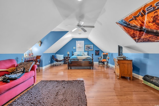 bedroom featuring a ceiling fan, lofted ceiling, baseboards, and wood finished floors