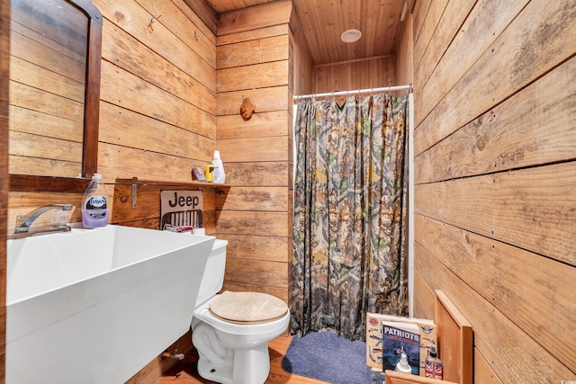 full bath featuring wooden ceiling, a sink, wooden walls, and toilet