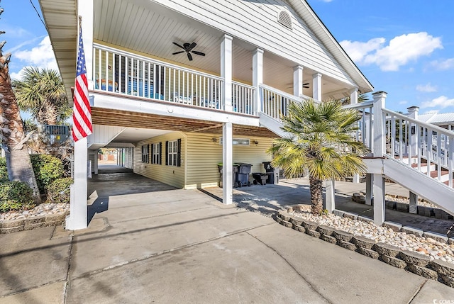 exterior space featuring a ceiling fan, driveway, a carport, and stairs