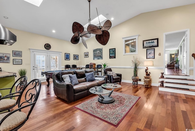 living room with stairs, french doors, lofted ceiling with skylight, and wood-type flooring