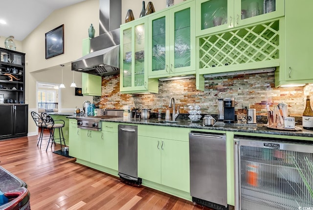 kitchen featuring wine cooler, stainless steel stovetop, backsplash, light wood-type flooring, and wall chimney exhaust hood