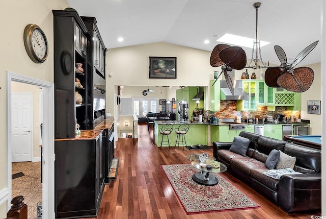 living room with dark wood-style floors, high vaulted ceiling, and bar area