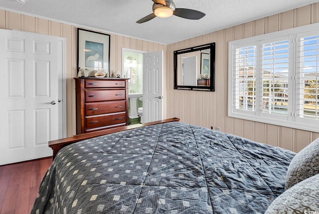 bedroom featuring connected bathroom, a textured ceiling, a ceiling fan, and wood finished floors