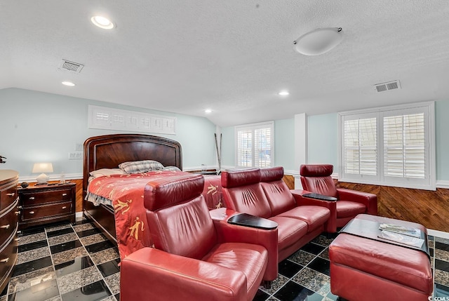 bedroom featuring lofted ceiling, a textured ceiling, visible vents, and baseboards