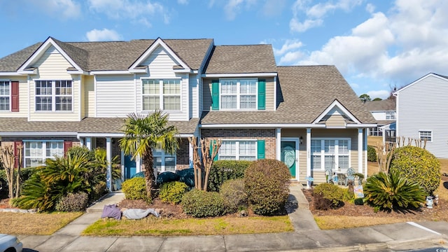 townhome / multi-family property with brick siding and roof with shingles