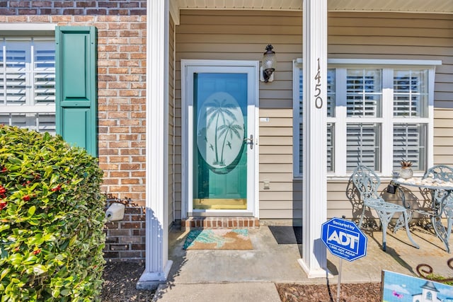 view of exterior entry featuring brick siding