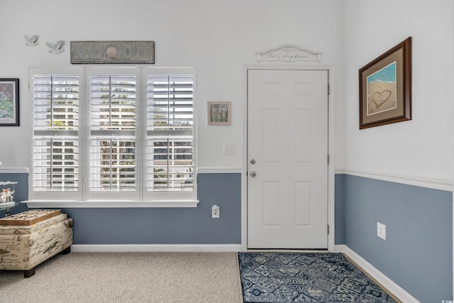 carpeted foyer entrance with baseboards