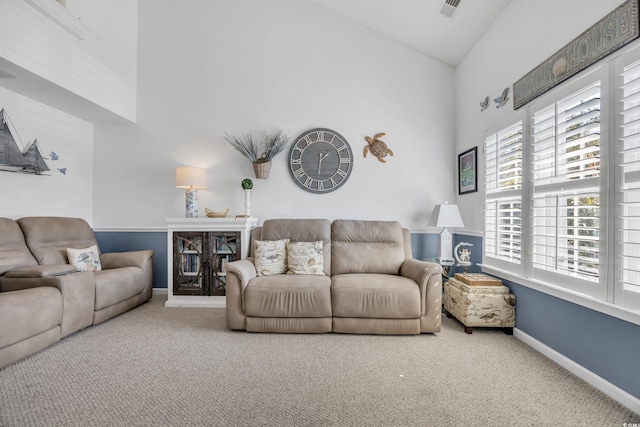 carpeted living room with high vaulted ceiling, visible vents, and baseboards