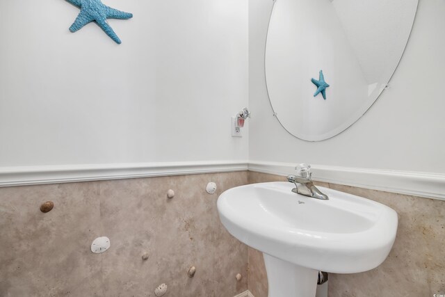 bathroom with a wainscoted wall and a sink