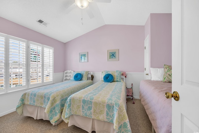 carpeted bedroom with a ceiling fan, visible vents, and vaulted ceiling