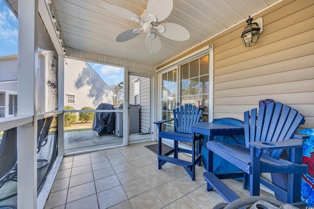 sunroom with ceiling fan and wooden ceiling