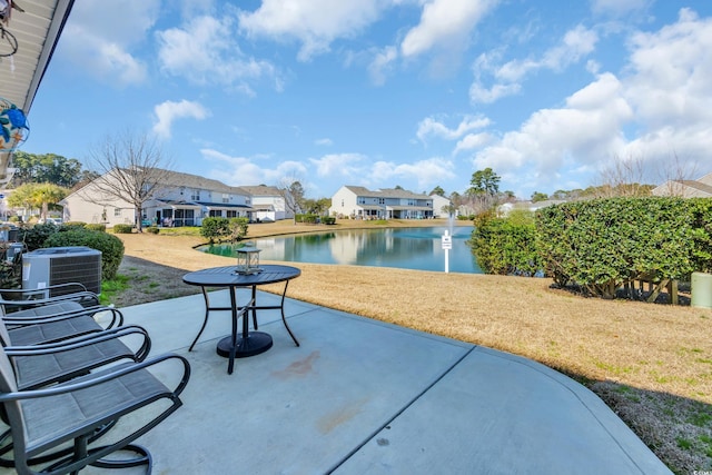 view of patio / terrace featuring central AC unit, a water view, and a residential view