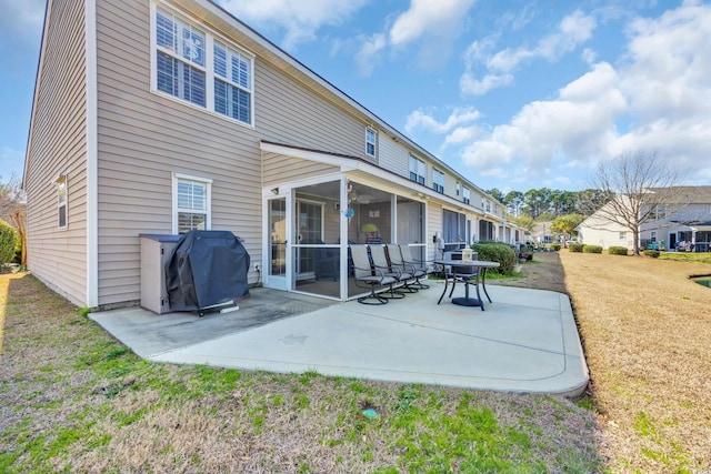 back of property with a patio area, a lawn, and a sunroom