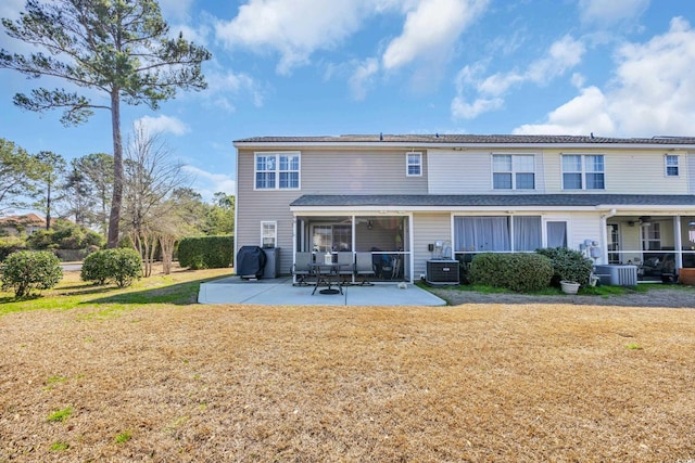 rear view of property featuring a yard, central AC unit, a patio area, and a sunroom