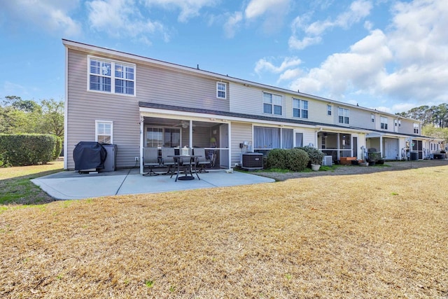 back of property with central AC, a patio, and a lawn