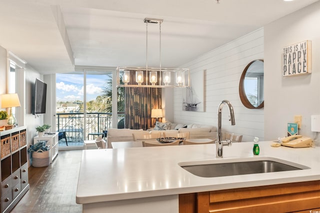 kitchen with light countertops, dark wood-style flooring, floor to ceiling windows, and a sink