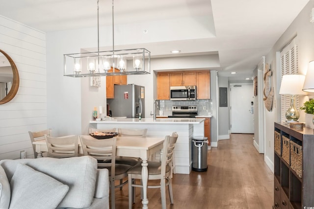 dining space featuring light wood-style flooring, recessed lighting, electric panel, and wooden walls