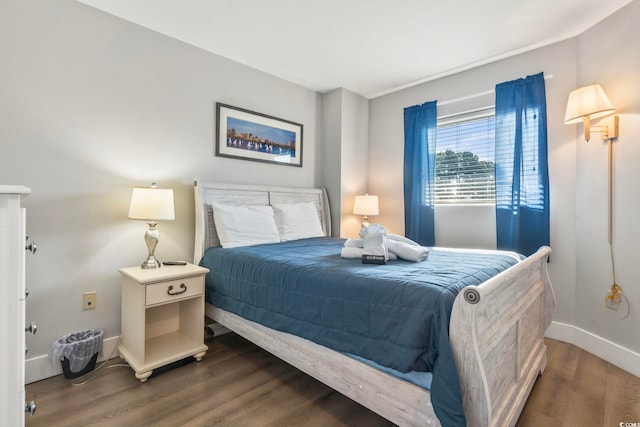 bedroom with baseboards and wood finished floors