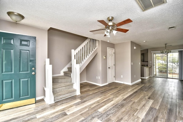 entrance foyer featuring wood finished floors, visible vents, baseboards, and stairs