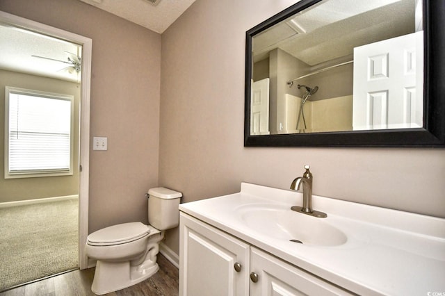 full bath featuring a shower, toilet, vanity, a textured ceiling, and wood finished floors