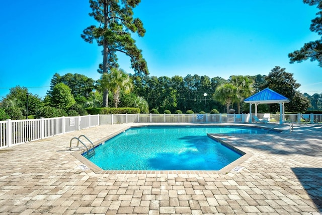 community pool featuring a patio area, fence, and a gazebo