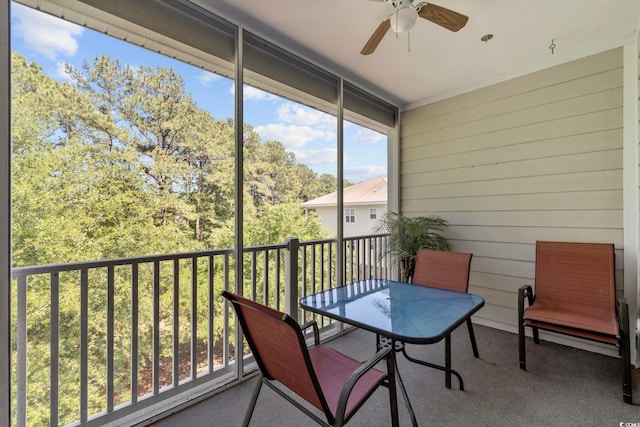 sunroom / solarium featuring a ceiling fan