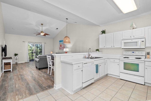 kitchen featuring a peninsula, white appliances, a sink, open floor plan, and light countertops