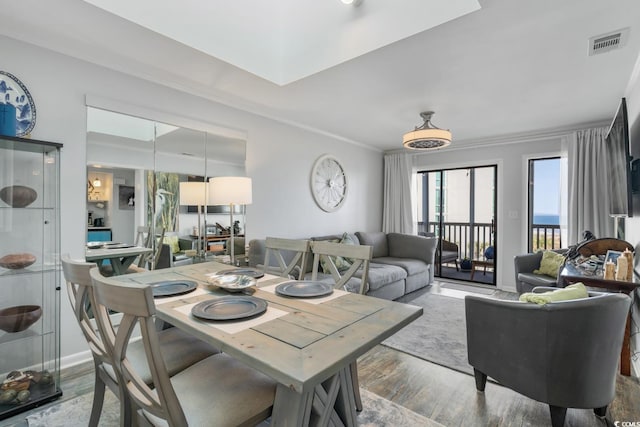 dining space featuring ornamental molding, visible vents, and wood finished floors