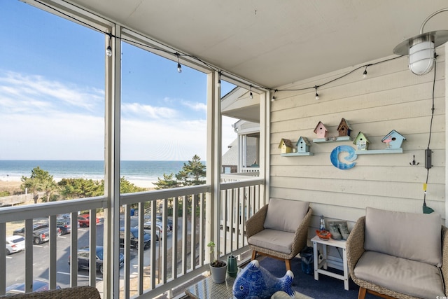 balcony featuring a water view and a view of the beach