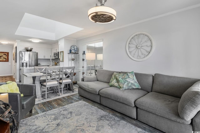 living room with baseboards, ornamental molding, and dark wood-type flooring