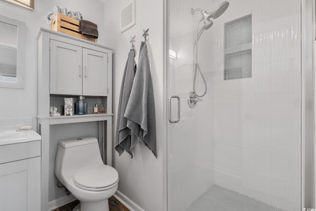 bathroom featuring toilet, a shower stall, visible vents, and vanity