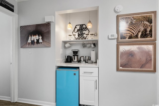 bar with a dry bar, baseboards, and refrigerator