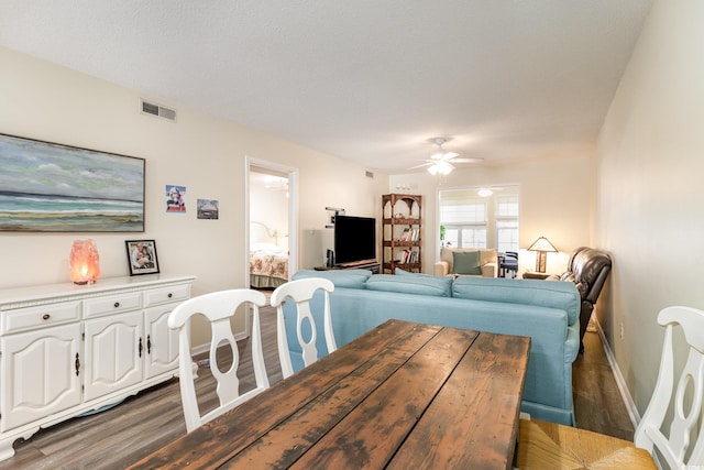 dining area with a ceiling fan, baseboards, visible vents, and wood finished floors