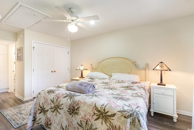 bedroom featuring attic access, baseboards, dark wood finished floors, and a closet