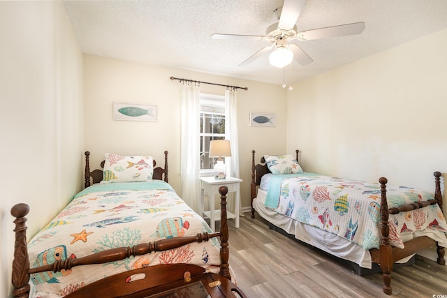 bedroom featuring a textured ceiling, ceiling fan, and wood finished floors