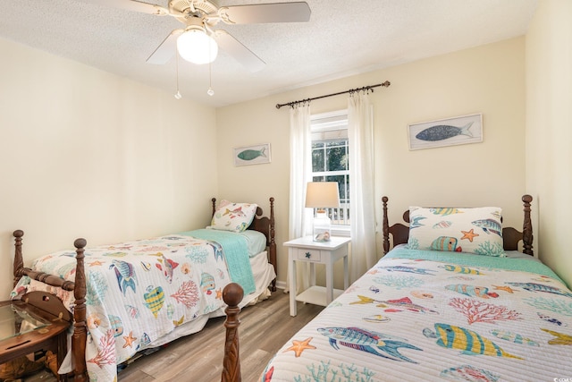 bedroom featuring ceiling fan, a textured ceiling, and wood finished floors