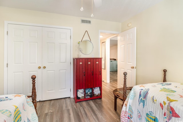 bedroom with a ceiling fan, a closet, visible vents, and wood finished floors