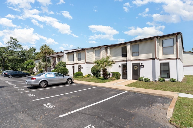 view of property featuring uncovered parking and a residential view