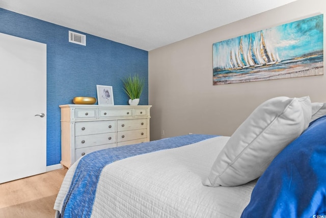 bedroom featuring visible vents and wood finished floors