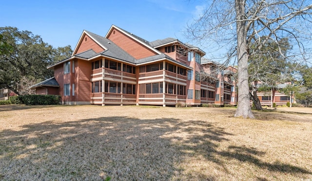 exterior space with a front lawn and roof with shingles