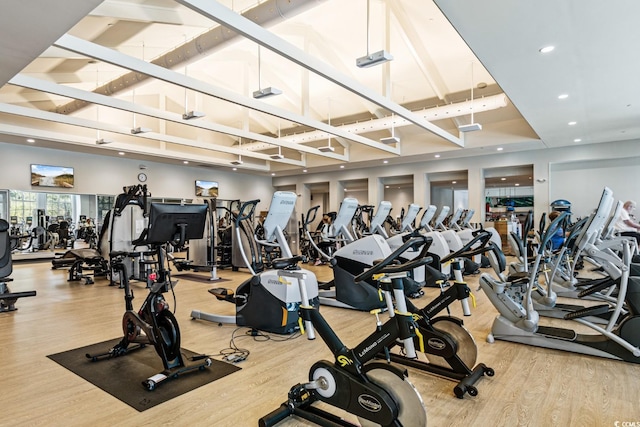 gym featuring high vaulted ceiling, wood finished floors, and recessed lighting