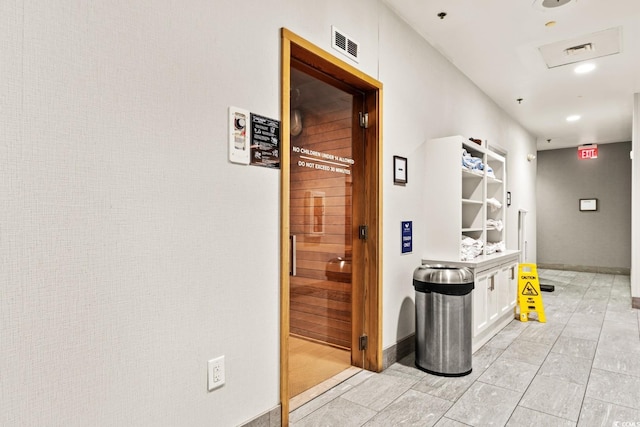 hallway with visible vents and baseboards