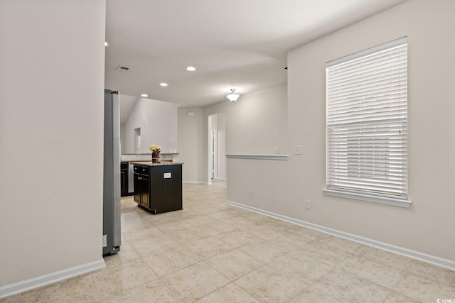 kitchen with freestanding refrigerator, visible vents, and baseboards