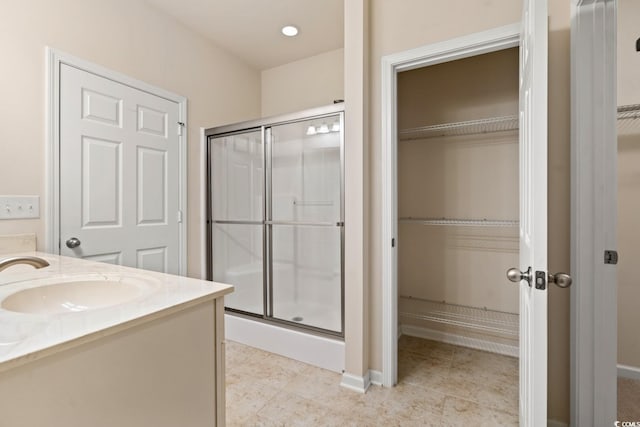 full bath with a stall shower, tile patterned flooring, a spacious closet, and vanity