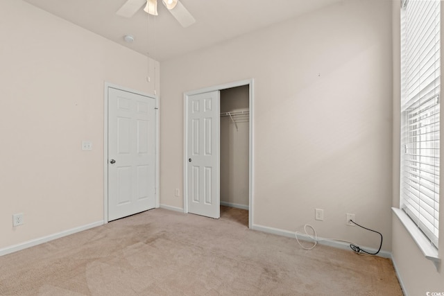 unfurnished bedroom featuring carpet floors, a closet, baseboards, and a ceiling fan