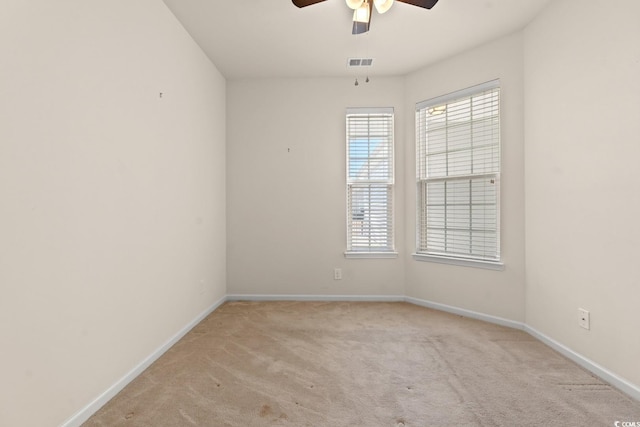 spare room with baseboards, visible vents, ceiling fan, and carpet flooring