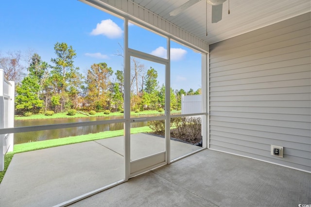 unfurnished sunroom with a water view and ceiling fan