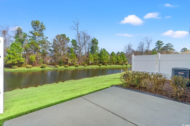 view of patio featuring a water view, fence, and central AC unit